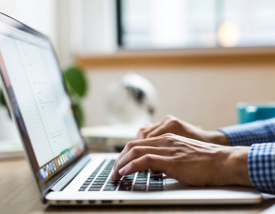 Hands on a laptop keyboard